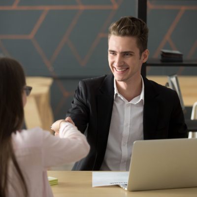 Smiling hr manager handshaking successful applicant hiring or greeting, friendly satisfied employer offering job contract shaking hand of winning candidate at interview, employment recruiting concept